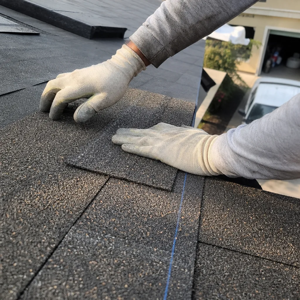 Professional roofer installing new asphalt shingles during a roof replacement project